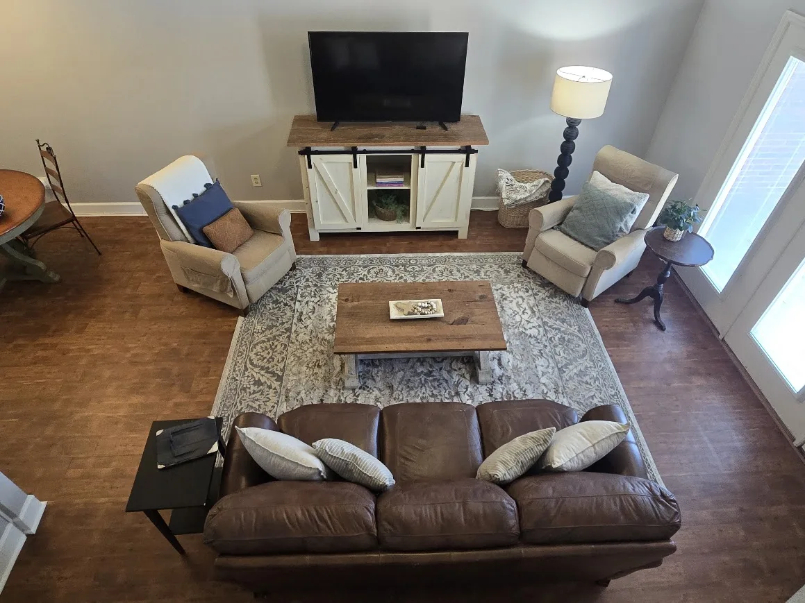 Furnished living room with sofa, chairs, area rug, and seating arrangement